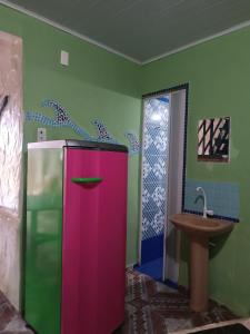 a colorful refrigerator in a bathroom with a sink at Kitnet no Farol Velho in Salinópolis