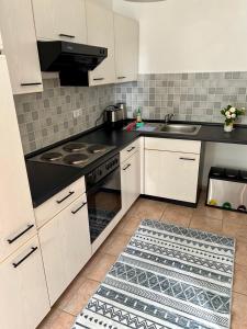 a kitchen with white cabinets and a black counter top at Nussbaumhof mit Koppel in Plath