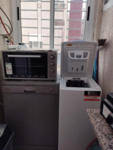 a microwave and a refrigerator in a small kitchen at Bel appartement calme est bien équipé in Meknès