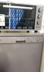 a microwave oven sitting on top of a refrigerator at Bel appartement calme est bien équipé in Meknès