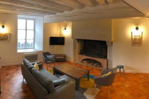 sala de estar con sofá y chimenea en Gite de charme avec piscine intérieure, en Amné-en-Champagne