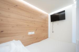 um quarto com uma cama e uma televisão na parede em Robin Wood Apartment em Viena