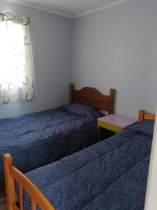 a bedroom with two beds and a table and a window at Casa verano in Caldera