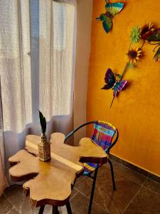 a table and a chair with butterflies on the wall at Sunset View, Taganga in Taganga