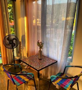 einen Tisch und zwei Stühle in einem Zimmer mit Fenster in der Unterkunft Sunset View, Taganga in Taganga