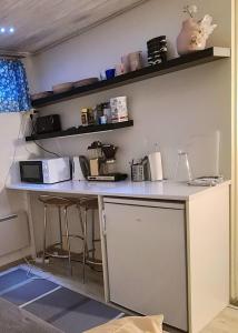 eine Küche mit einer Theke und einer Mikrowelle in der Unterkunft Rauhallinen kaksio Lahdentie tuntumassa, lentokenttämajoitus ja sähköauton latauspiste in Vantaa