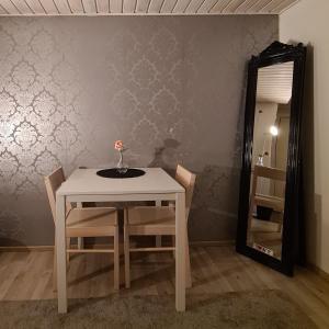 a dining room table with a vase on it and a mirror at Rauhallinen kaksio Lahdentie tuntumassa, lentokenttämajoitus ja sähköauton latauspiste in Vantaa