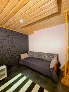 a bed in a room with a wooden ceiling at Rauhallinen kaksio Lahdentie tuntumassa, lentokenttämajoitus ja sähköauton latauspiste in Vantaa