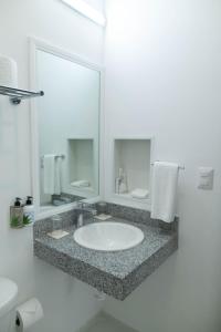 a bathroom with a sink and a mirror at Hotel & Suites Yuca Ville Siglo XXI in Mérida