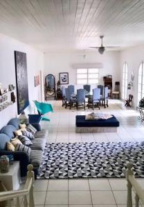 uma ampla sala de estar com um sofá e cadeiras em Casa Canasvieiras Florianópolis com piscina e mar em Florianópolis