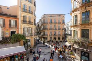 a group of people walking through a city street at Diana Suites 23 in Málaga