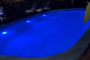 uma grande piscina azul com duas cadeiras à volta em Casa Canasvieiras Florianópolis com piscina e mar em Florianópolis