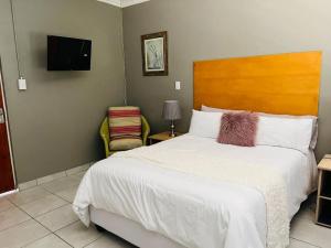 a bedroom with a large bed and a television at Bachelor suite in Rustenburg in Rustenburg
