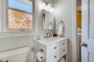a white bathroom with a sink and a window at Waterfront Lake Tillery Home with Incredible Views! in Mount Gilead +34 photos
