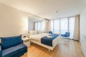 um quarto com uma cama e um sofá azul em 0rbi City Luxury Suites em Batumi