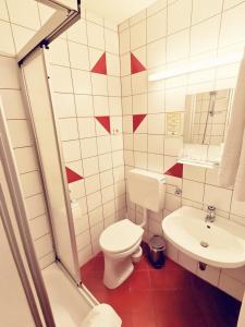 een witte badkamer met een toilet en een wastafel bij Hotel Gasthof Stranachwirt in Sankt Michael im Lungau