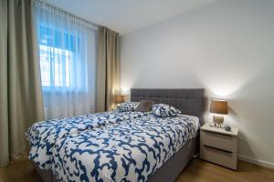 a bedroom with a blue and white bed with a window at Flexible SelfCheckIns 63 - Zagreb - Parking - Loggia - Brand New in Zagreb
