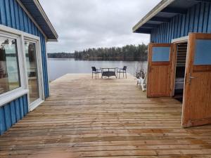 un quai en bois avec une table et des chaises sur un lac dans l'établissement Mulseryd, à Bottnaryd