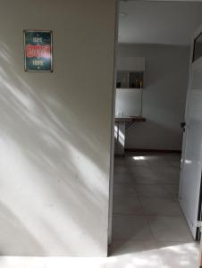 um quarto com uma parede branca com um cartaz em Casa Buda em Villa Gesell