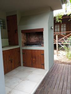 an outdoor kitchen with wooden cabinets on a deck at Casa Buda in Villa Gesell