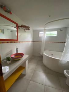 a bathroom with a tub and a sink at Casa Buda in Villa Gesell