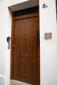 Una puerta marrón en un edificio con un cartel. en La Casa di Hank, en Imola