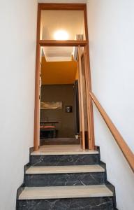 Una escalera que conduce a una habitación con espejo en La Casa di Hank, en Imola