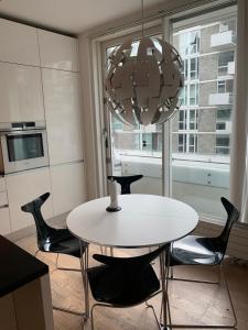 uma sala de jantar com uma mesa branca e cadeiras pretas em High-end luxury apartment on Islands Brygge. em Copenhague