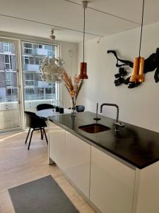 uma cozinha com um balcão com um lavatório e uma mesa em High-end luxury apartment on Islands Brygge. em Copenhague