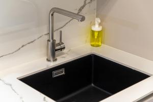Un fregadero de cocina con un grifo sobre una encimera en Flexible SelfCheckIns 63 - Zagreb - Loggia - Brand New, en Zagreb 20 fotos más