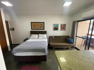 a bedroom with a bed and a couch in it at RAVENA 11 in Ribeirão Preto