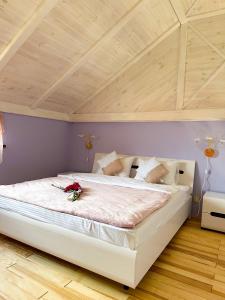 a large white bed in a room with a wooden ceiling at Na Pagorbi Lutsk in Luts'k