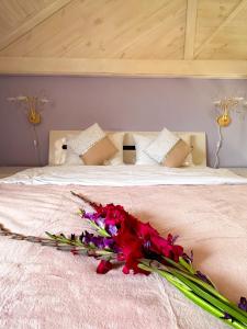 Ein Bett mit einem Haufen Blumen drauf. in der Unterkunft Na Pagorbi Lutsk in Luzk