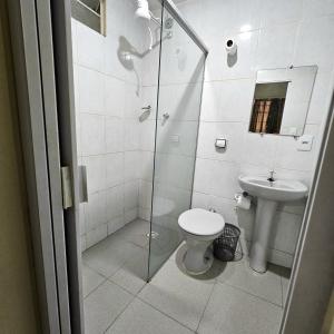 a bathroom with a toilet and a glass shower at Hotel Turista in Belo Horizonte +46 photos