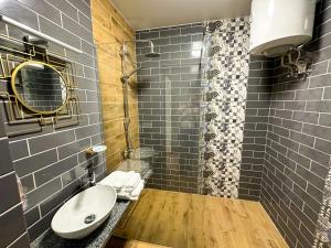 W łazience znajduje się umywalka i prysznic. w obiekcie Na Pagorbi Lutsk w mieście Łuck