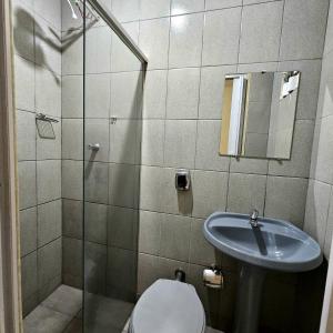 y baño con lavabo, aseo y ducha. en Hotel Turista, en Belo Horizonte