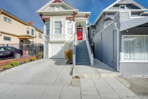 uma casa branca com uma porta vermelha numa rua em Bikeable Apartment - 2 Mi to Downtown Oakland! em Oakland
