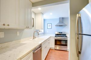 uma cozinha com armários brancos, um lavatório e um frigorífico em Bikeable Apartment - 2 Mi to Downtown Oakland! em Oakland