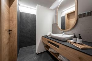 bagno con lavandino e specchio di DILIA Chalets & Apartments a Mühlbach