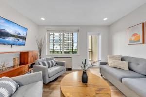 a living room with two couches and a table at Downtown Condo Walk To Mercedes Benz Stadium in Atlanta