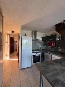 Il comprend une cuisine équipée d'un réfrigérateur blanc. dans l'établissement Agora - Dernier étage - Vue mer, à Argelès-sur-Mer