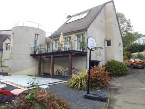 a house with a balcony and a basketball hoop at Le jardin d'eden in Lourdes