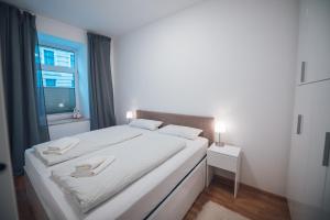 uma cama branca num quarto com uma janela em Apartment nähe Stadthalle em Viena