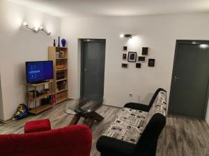 ein Wohnzimmer mit einem Sofa, einem Tisch und einem TV in der Unterkunft Skitnica Life in Koprivnica