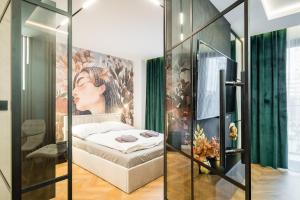 a bedroom with a bed and a painting on the wall at Greendustry Zabłocie Luxury Apartments WAWELOFTS in Kraków