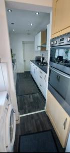 a kitchen with a stove and a washing machine at Paradise Street Contractor Haven in Barrow in Furness