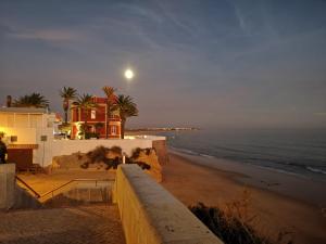 una luna sobre una playa con una casa y el océano en Apartment Sweet Pear with garage, en Armação de Pêra