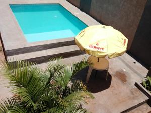 ein gelber Sonnenschirm neben einem Swimmingpool in der Unterkunft CardónApart in Puerto Iguazú + 9 Fotos
