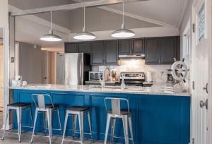 a kitchen with a blue island with bar stools at PRIVATE BEACH - Ocean Front on Coffin Point in Cedar Reef Villas +16 photos