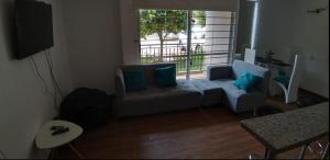 uma sala de estar com um sofá e uma grande janela em Apto en conjunto cerrado con piscina. em Ricaurte